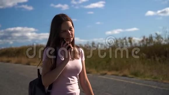 年轻女孩在电话旁说话背着背包走在路上视频的预览图