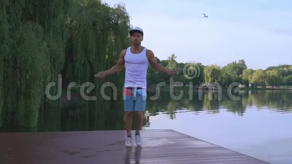 肌肉发达的年轻人在湖边跳绳视频的预览图
