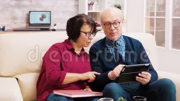 老年夫妇坐在沙发上用平板电脑视频的预览图
