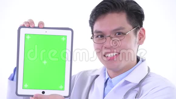 一位年轻快乐的亚洲男子医生展示数码平板电脑视频的预览图