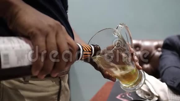 把啤酒倒在杯子里从瓶子里产生泡沫视频的预览图