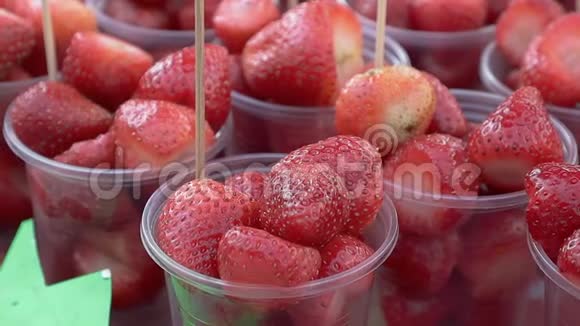 新鲜草莓水果在市场上的塑料杯视频的预览图