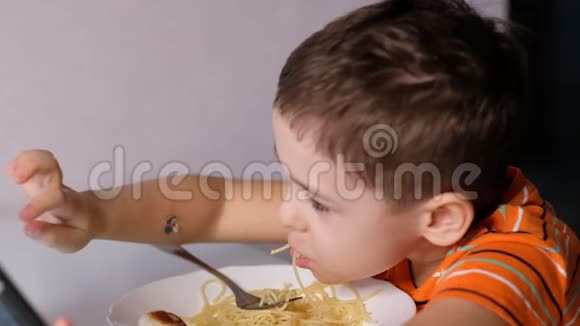 孩子们在餐桌上玩意大利面糟糕的脸吃东西酱汁和孩子男孩坐在托儿所吃面条视频的预览图