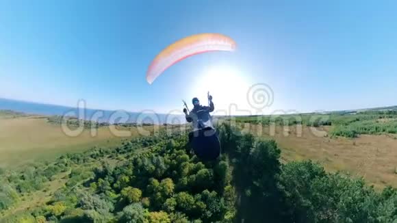 一个人用公绵羊降落伞飞行的正面视图人滑翔伞美丽的自然背景视频的预览图