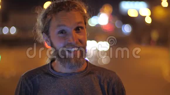一个英俊的白种人长胡子的年轻男子微笑着直视着摄像机说话并在镜头上伸出大拇指视频的预览图