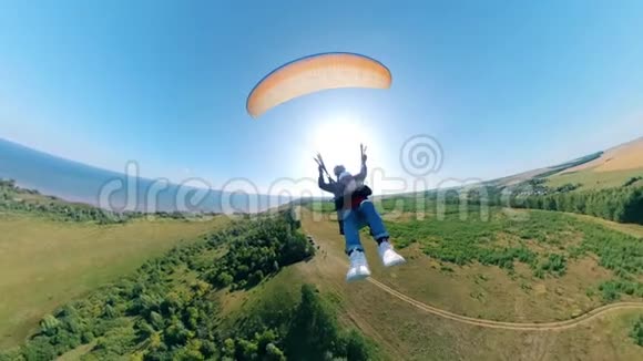 前面看到两个人在滑翔伞上飞行人滑翔伞美丽的自然背景视频的预览图