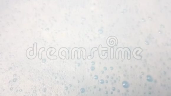 白色泡沫泡沫泡在蓝色水特写视频的预览图