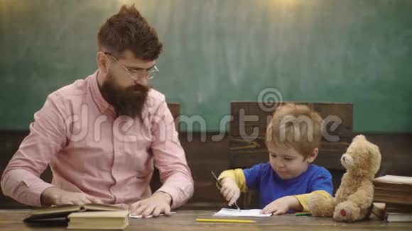 幼儿教育与游戏观念爸爸带着儿子画画爸爸和小男孩一起画画学校视频的预览图