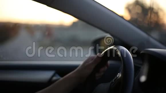 汽车驾驶车轮上男性手的特写背景阳光的日落效果视频的预览图