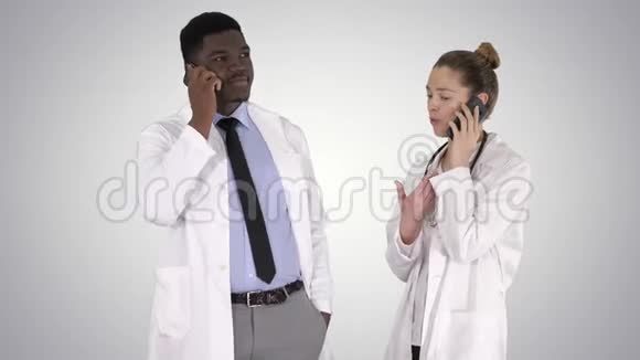 女性和男性医生使用手机打电话在梯度背景下告诉快乐的消息视频的预览图