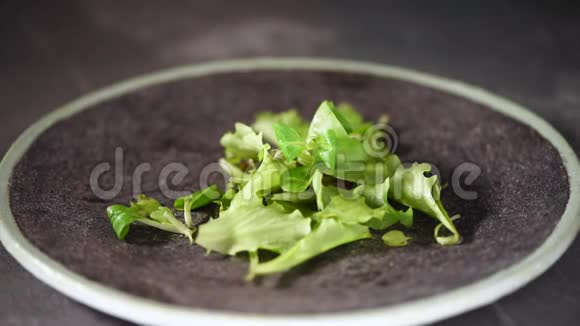 素和生食概念混合掉在石盘上的绿色沙拉上景视频的预览图