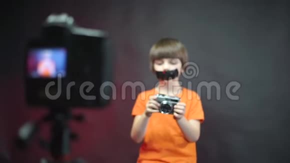 一个脸上贴着胶带的视频博主记录了一段关于相机的视频视频的预览图