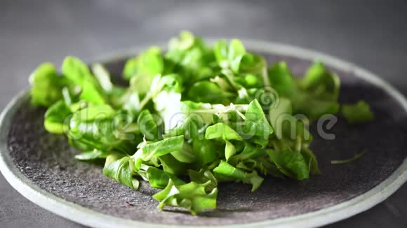 混合掉在石盘上的绿色沙拉上景素和生食概念视频的预览图