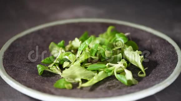 素和生食概念混合掉在石盘上的绿色沙拉上景视频的预览图