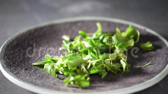 混合掉在石盘上的绿色沙拉上景素和生食概念视频的预览图