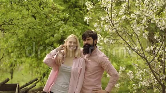 春天的情侣在盛开的花园里地球日绿草地景观一个农民男子和一个农民妇女视频的预览图