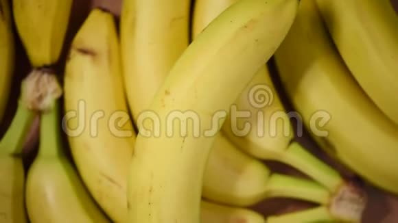 旋转背景上的香蕉上景素和生食概念一串黄色香蕉视频的预览图