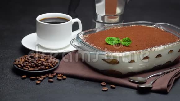 玻璃烤盘中的提拉米苏甜点一杯浓缩咖啡和一个具体背景的咖啡机视频的预览图