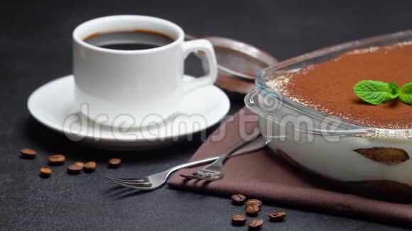 玻璃烤盘中的提拉米苏甜点和混凝土背景下的一杯浓咖啡视频的预览图