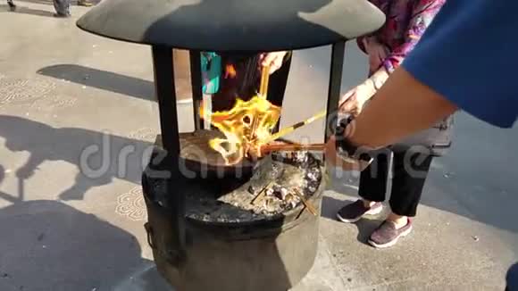 庙火中点燃传统佛教祈祷棒的人们视频的预览图