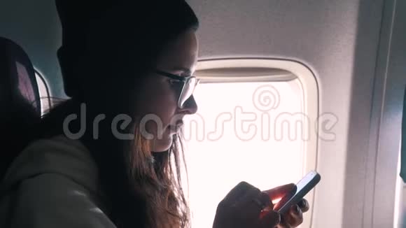 女孩在飞行时使用智能手机视频的预览图