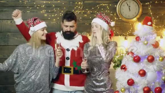 圣诞派对一起庆祝新年一群戴圣诞帽的漂亮年轻人喝着香槟和视频的预览图