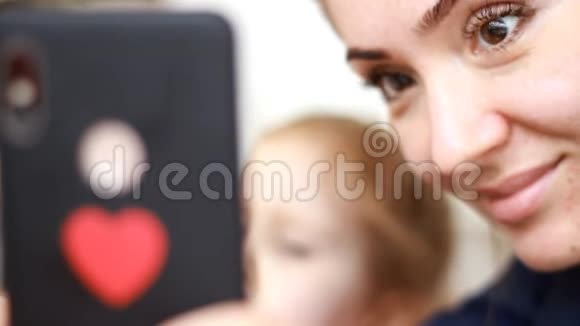 一个女人和她的孩子用手机的特写肖像视频的预览图