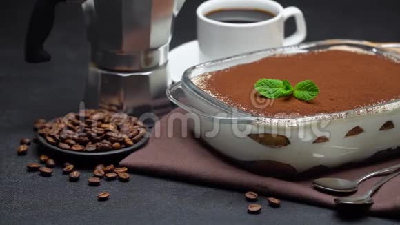 玻璃烤盘中的提拉米苏甜点一杯浓缩咖啡和一个具体背景的咖啡机视频的预览图