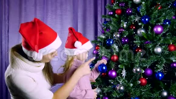 幸福的家庭母亲和孩子女孩装饰了一棵圣诞树视频的预览图