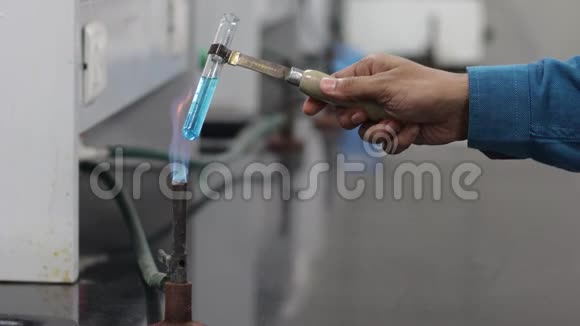 在蓝色燃烧器火焰上试管中加热蓝色化学物质视频的预览图