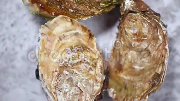 新鲜牡蛎在灰色大理石旋转背景海鲜餐盘视频的预览图