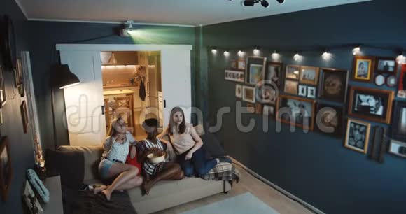 高角度快乐美丽多样化女性朋友一起在家看电影用投影仪慢镜头视频的预览图