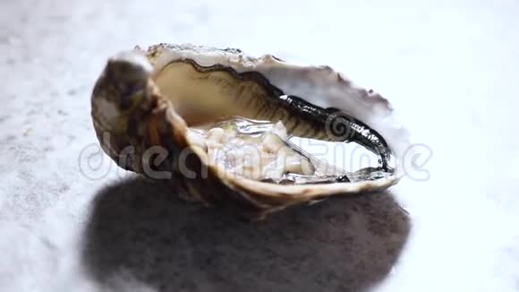 在灰色大理石旋转背景上打开牡蛎海鲜餐盘视频的预览图