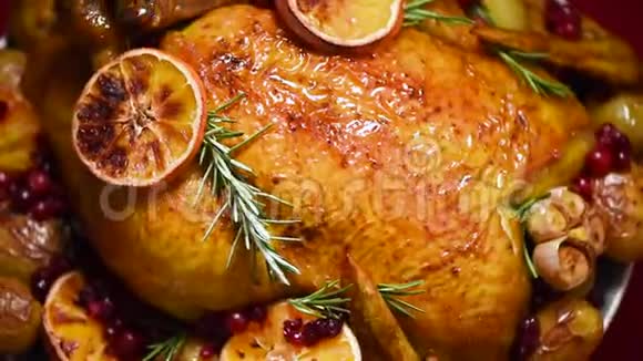 圣诞家庭晚餐烤鸡用草药橙子蔓越莓旋转背景慢镜头拍摄视频的预览图