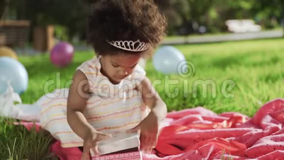 快乐的非洲裔小女孩在生日时玩礼物盒视频的预览图