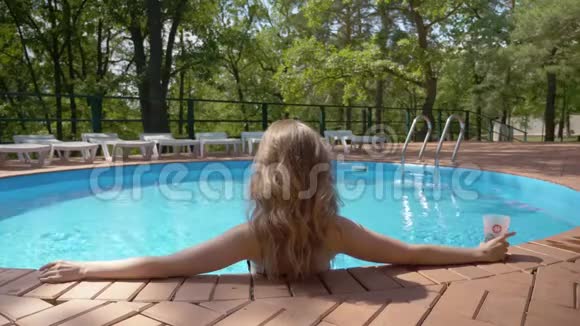 年轻放松的女士正在酒店的游泳池里享受夏日的好天气视频的预览图