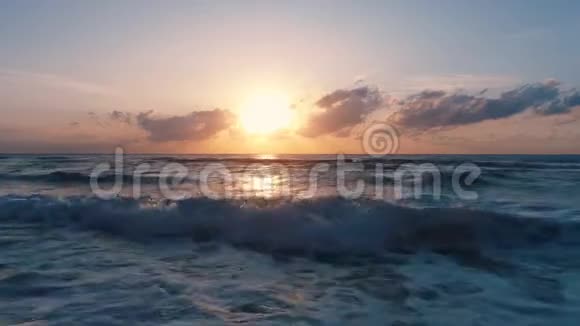 热带海滩和美丽的海上日出戏剧性的云彩和舞动的波浪视频的预览图