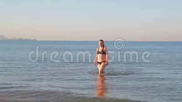 一个穿着运动泳衣的黑发女人在做瑜伽后去海里游泳视频的预览图