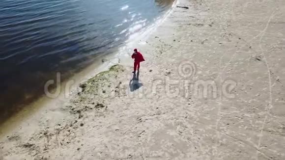 圣诞老人拿着一袋礼物站在湖边荒岛上的圣诞老人顶部视图视频的预览图