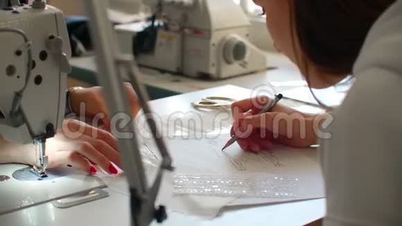 特写女性时装设计师绘制服装草图并挑选材料和配饰小裁缝生意视频的预览图