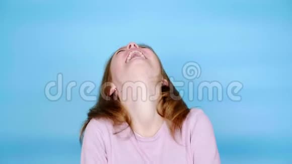 穿着粉红色套头衫的快乐少女正在笑着看着镜头视频的预览图