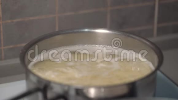 煮熟的手用沸水在银锅中搅拌意大利面视频的预览图
