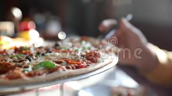 一个男人的手拿着一片热气腾腾的美味海鲜披萨披萨上有山柑和橄榄视频的预览图