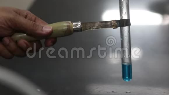 在化学实验室的试管中将塑料洗瓶器中的液体化学物质倒入蓝色化学物质视频的预览图
