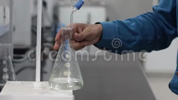 滴定管在锥形瓶中摇动无色液体的滴定反应视频的预览图