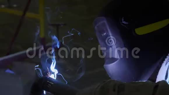 特殊面罩的员工在黑暗处焊接有火花的管道视频的预览图