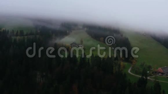 在即将到来的大雾中Drone在山区山谷草地上拍摄了秋季灰色多云天气的反向飞行视频的预览图