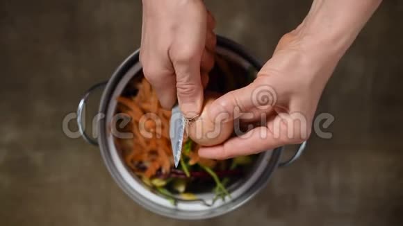 减少食物浪费妇女在堆肥桶里扔蔬菜剥皮纸屑和果皮上景分类视频的预览图