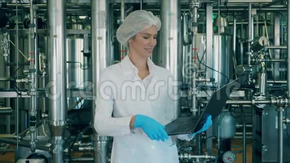 有笔记本电脑的女工正站在工厂里视频的预览图