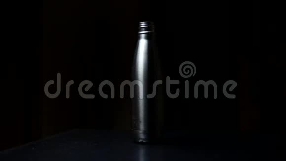 特写可重复使用的钢制热生态水瓶和盖子黑色背景视频的预览图